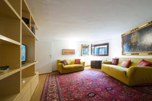 a living room with two yellow couches and a red rug at Heart of Venice in Venice