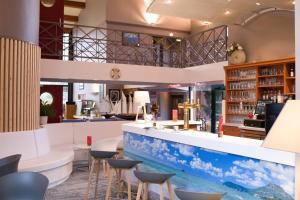 a bar with a blue and white counter and stools at The Originals City, Hôtel Le Sextant, Toulouse Sud in Labège