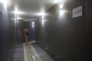 a person standing in a bathroom with a mirror at Araucaria Hotel & Spa in La Plagne
