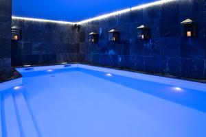 a blue and white swimming pool in a dark room at Araucaria Hotel & Spa in La Plagne