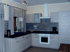 a kitchen with white cabinets and a stove top oven at Attractive Holiday Home in Frielendorf with Fenced Garden in Börgerende-Rethwisch