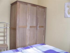 a large wooden cabinet in a bedroom with a bed at Attractive Holiday Home in Frielendorf with Fenced Garden in Börgerende-Rethwisch