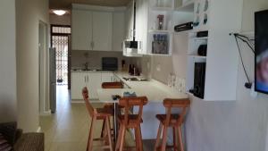 eine Küche mit einem Tisch und 4 Stühlen in der Unterkunft Cabanas del Mar in Amanzimtoti