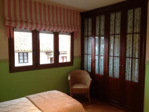 ein Schlafzimmer mit grünen Wänden, einem Bett und einem Fenster in der Unterkunft Apartamento Puerto De Llanes in Llanes