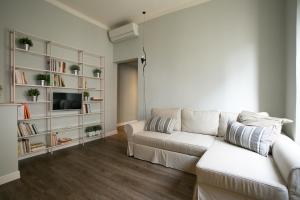 a living room with a white couch and book shelves at Cola Di Rienzo A E B in Rome