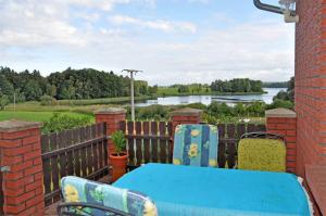 CarpinにあるFerienhaus Carpin SEE 3031の川の景色を望むバルコニー(青いテーブル、椅子付)