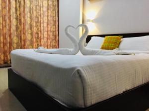 two swans made out of towels on a bed at The Cliff Resort, Munnar in Munnar