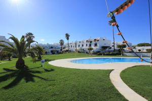 a swimming pool in a park with palm trees and buildings at Windmill Hill in Albufeira