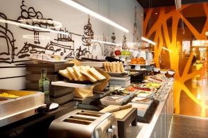 a buffet line of food in a restaurant at Evenia Rossello in Barcelona