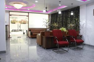 - un hall avec une salle d'attente dotée de chaises rouges et d'une table dans l'établissement GVK Inn, à Visakhapatnam