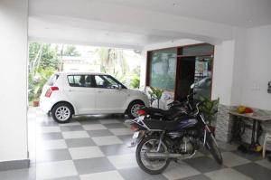 une moto garée dans un garage à côté d'une voiture dans l'établissement GVK Inn, à Visakhapatnam