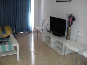 a living room filled with furniture and a tv at Hostal Alfonso in Cala Ratjada