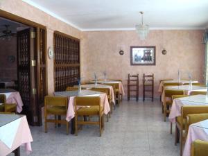 un restaurante con mesas y sillas con mantel rosa en Hostal Alfonso en Cala Ratjada