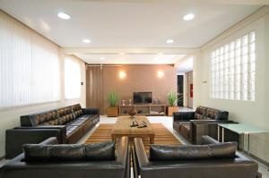uma sala de estar com mobiliário de couro e uma mesa em Hotel 2 Gauchos em Naviraí