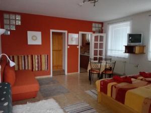 a living room with a bed and a dining room at Ottó Panzió Villány in Villány