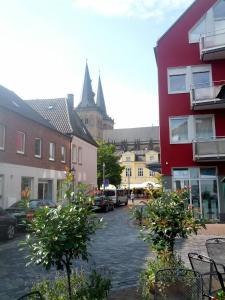 a street in a town with buildings and trees at Weindepot Xanten in Xanten