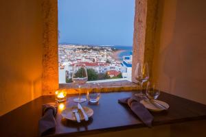 a table with four wine glasses and a window at Windmill Hill in Albufeira