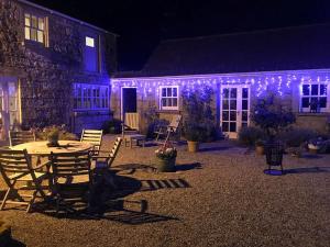 una casa con luci viola sul lato di Courtyard Cottage a Carlow