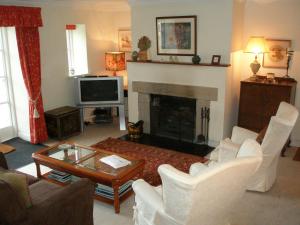 a living room with white furniture and a fireplace at Courtyard Cottage in Carlow