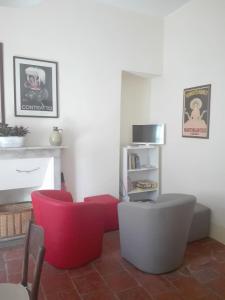 a living room with red chairs and a fireplace at Casa Ternavassi in Carmagnola