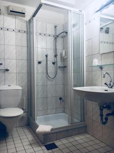 a bathroom with a shower and a toilet and a sink at SSC Sport+Seminarcenter Radevormwald in Radevormwald