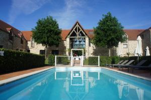 a swimming pool in front of a building at Hotel Les Suites - Domaine de Crécy in Crécy-la-Chapelle