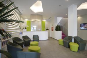 a waiting room with green and white chairs and stairs at Hotel Gardenia in Lido di Jesolo