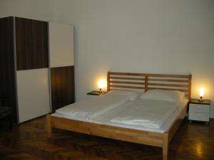 a bedroom with a large bed with two lamps on it at Pension Schottentor in Vienna