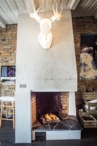 a statue of a deer standing over a fireplace at Lilland Brewery Hotel in Tau