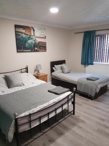 sypialnia z dwoma łóżkami i zdjęciem samochodu na ścianie w obiekcie The Bay Horse Accommodation w mieście Carlton