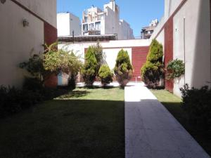 a courtyard of a building with trees and a sidewalk at Luminoso monoambiente en Recoleta in Buenos Aires