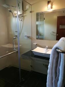 a bathroom with a sink and a shower with a mirror at Villa A50 in Negombo