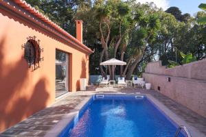 a swimming pool in the backyard of a house at Funchal Charming Villa in Funchal