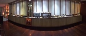 a large lobby with a long counter with food on it at Hotel Maerkli in Santo Ângelo