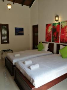 duas camas sentadas uma ao lado da outra num quarto em Villa A50 em Negombo