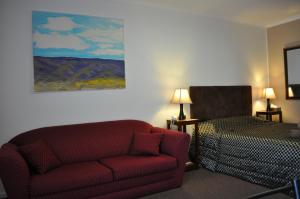 
a living room with a couch and a bed at Augusta Courtyard Motel in Port Augusta
