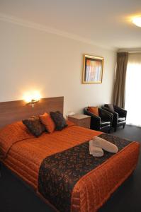 um quarto de hotel com uma cama e uma cadeira em Augusta Courtyard Motel em Port Augusta