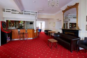 a living room with a couch and a bar at The Bournemouth Maemar Hotel in Bournemouth