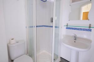 een witte badkamer met een toilet en een wastafel bij The Bournemouth Maemar Hotel in Bournemouth