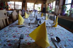 a table with yellow napkins and wine glasses on it at Panoramapension Platzer in Unterkolbnitz