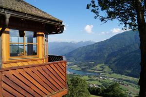 a house with a view of a river and mountains at Panoramapension Platzer in Unterkolbnitz