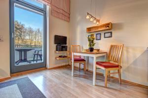 ヘリングスドルフにあるVilla Inge Wohnung 6のテーブルと椅子、窓が備わる客室です。