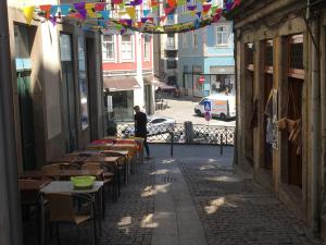 an alley with tables and chairs on a street at São Bento Golden Flat in Porto