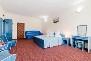 a bedroom with blue furniture and a bed and a mirror at Hotel Belvedere in Piatra Neamţ