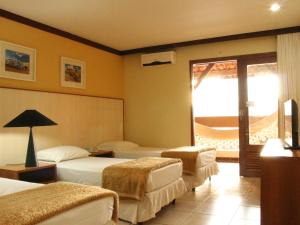 a hotel room with two beds and two lamps at Garden Hotel in Campina Grande