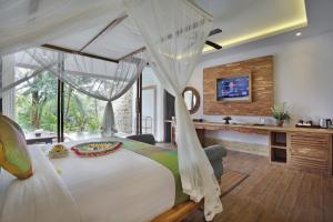 a bedroom with a large white bed with a desk at Bucu View Resort in Ubud