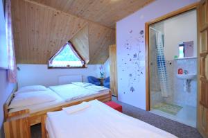 a small bedroom with two beds and a shower at Ubytovanie Sokolica in Červený Kláštor