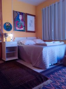 a bedroom with a bed with a table and a window at Mini Hostel Fine Art in Vitória da Conquista
