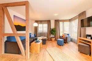 ein Wohnzimmer mit einem Bett und einem Sofa in der Unterkunft Casatina Ferienwohnungen in Oberstdorf