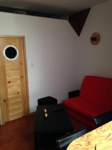 een woonkamer met een rode bank en een deur bij Big in Narbonne